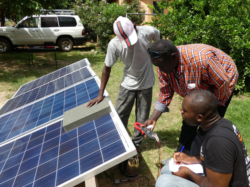 Drei Kursteilnehmer messen die Bypassdiode unter der Verschattung eines Solarpanels an einer Versuchsanlage.