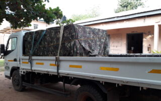 Ein beladener Truck steht auf dem Areal des SILAP Guesthouses, die Solarpanels sind mit einer Militärplane abgedeckt.