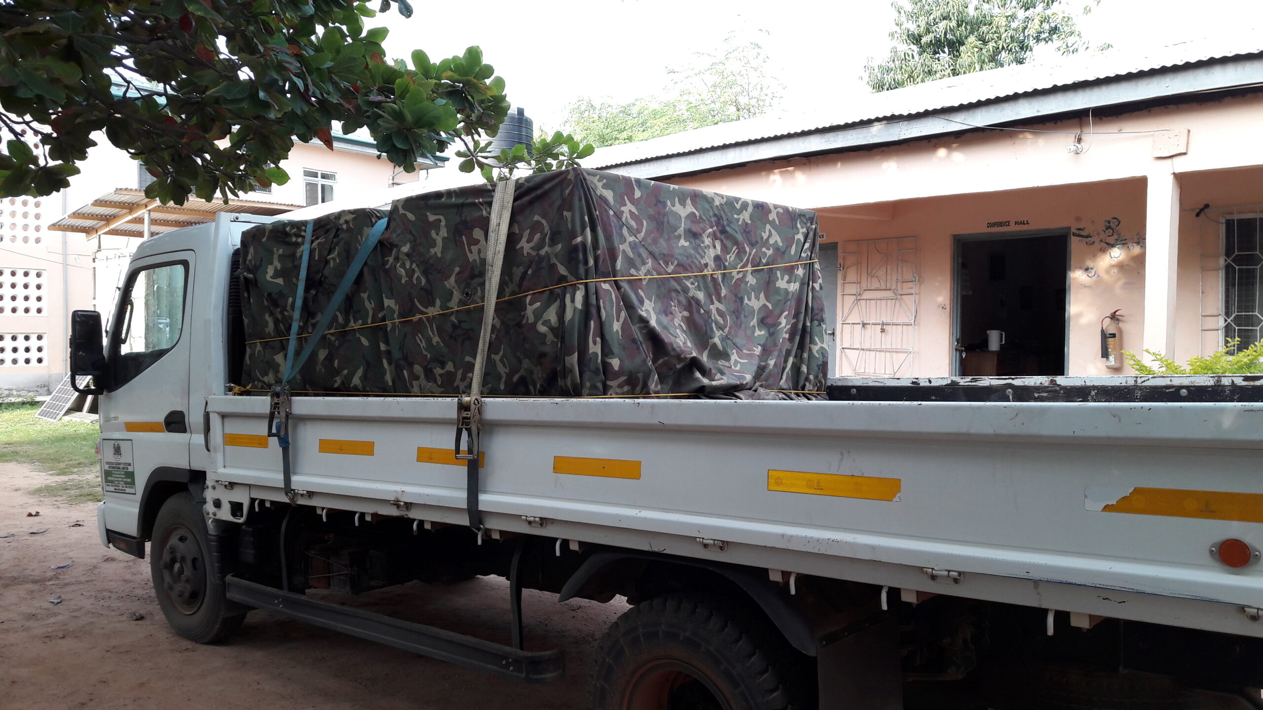 Ein beladener Truck steht auf dem Areal des SILAP Guesthouses, die Solarpanels sind mit einer Militärplane abgedeckt.