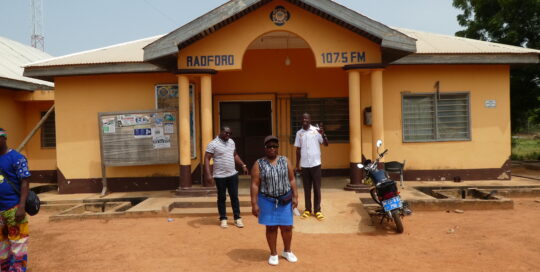 Tosin, Abigail und John stehen vor dem Radford Radio in Tumu