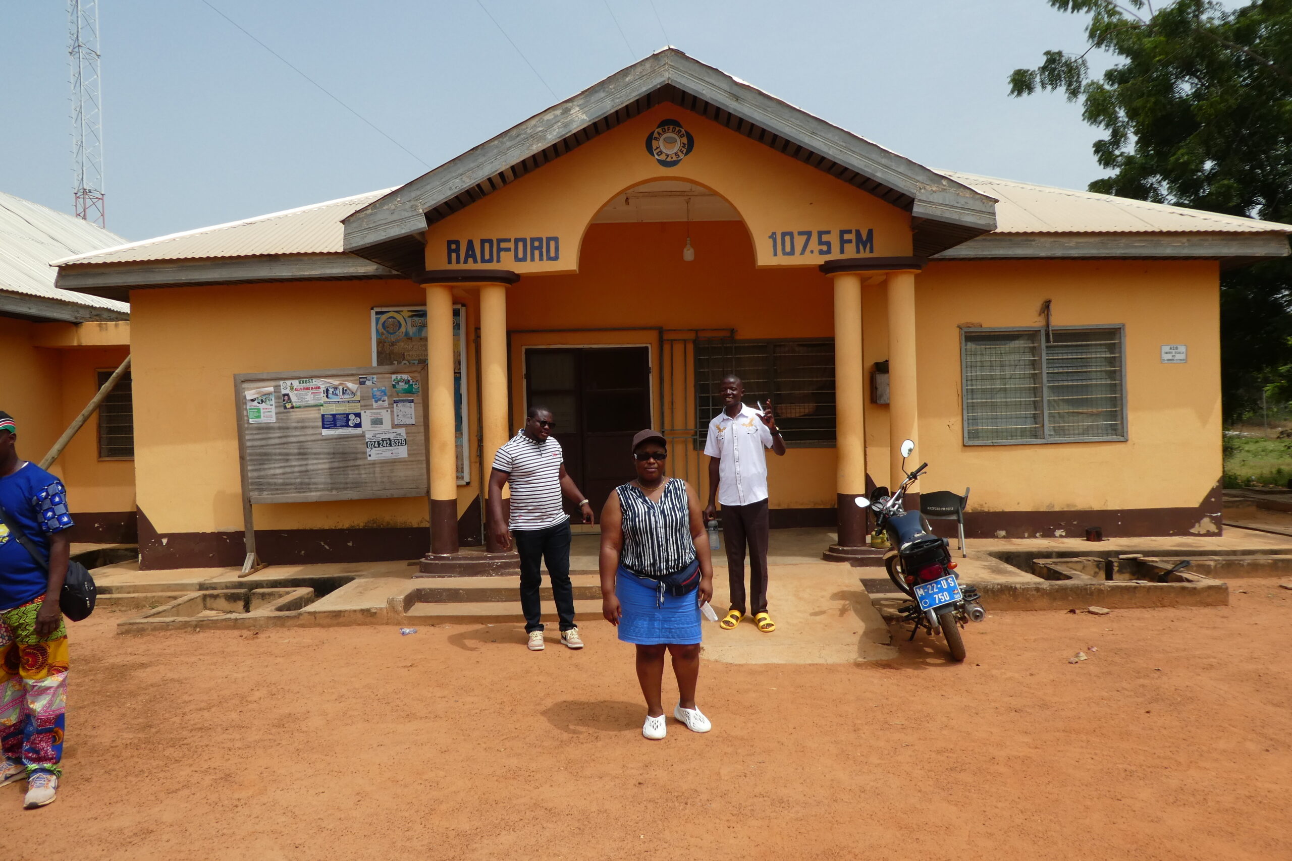 Tosin, Abigail und John stehen vor dem Radford Radio in Tumu