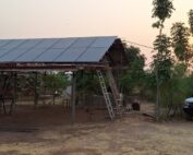 Die PV-Anlage in Bimbilla von vorne, daneben ein Pickup-Truck, ein gängiges Auto für Ghana, mit einem schönen Sonnenuntergang im Hintergrund.
